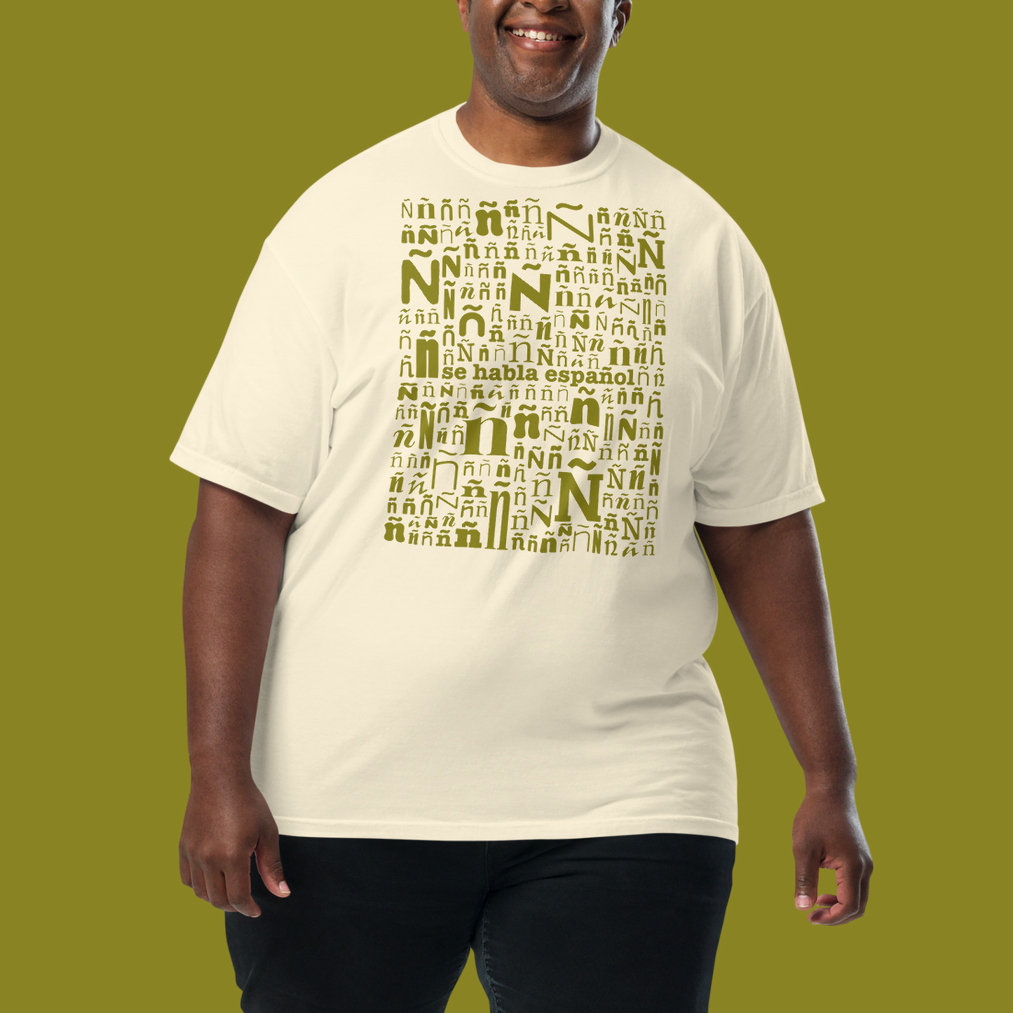 Model wearing a cream shirt with design of tens of ñs and "se habla español" in the middle.