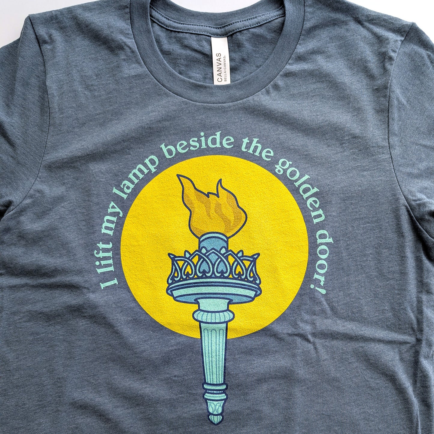 I lift my lamp beside the golden door! Bella Canvas Unisex T-Shirt - Circle Design